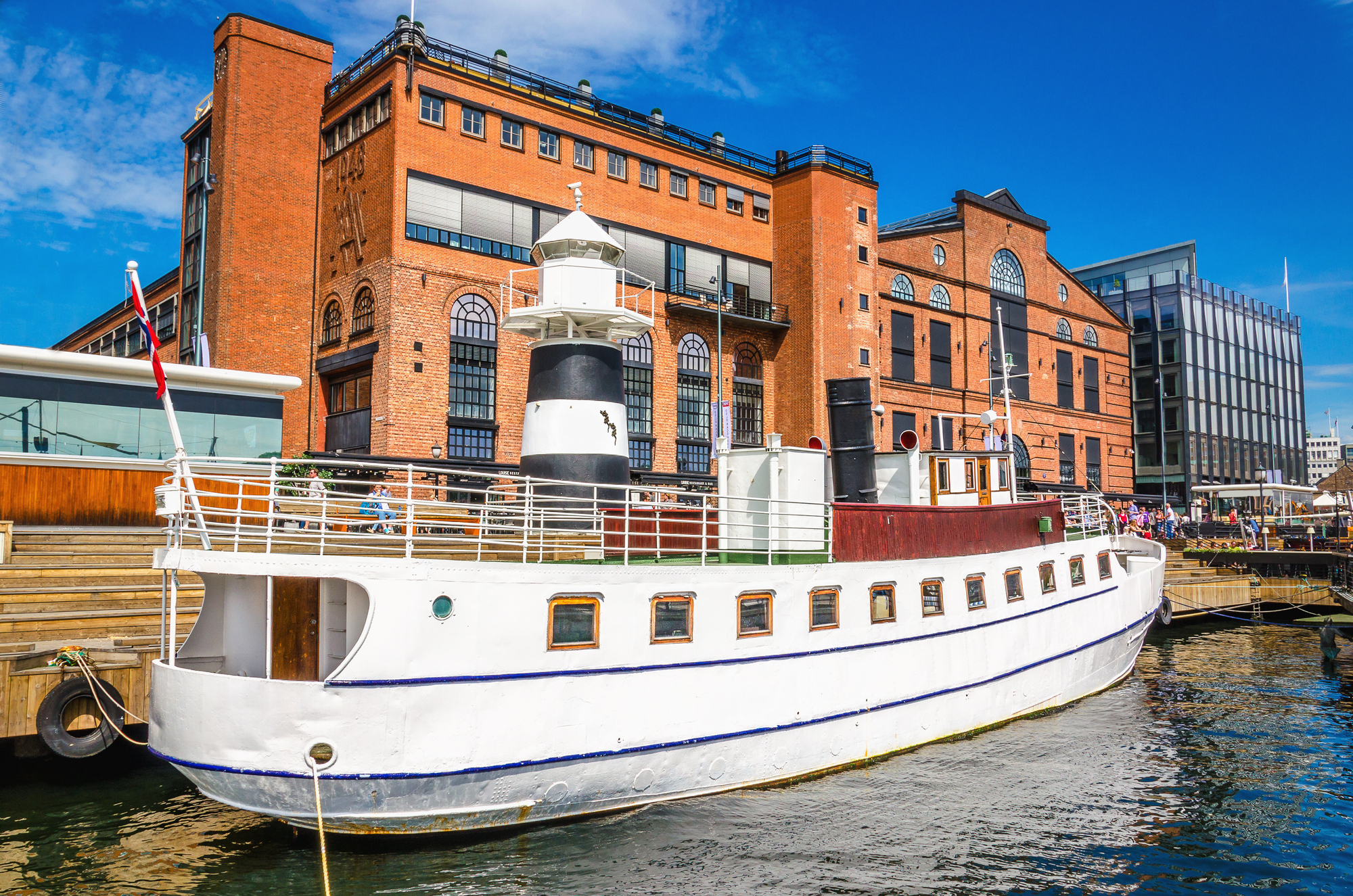Aker Brygge, em Oslo, com um iate branco no porto