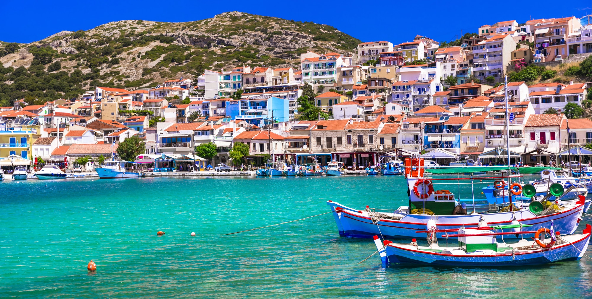 Barcos de pesca coloridos e casas ao longo da orla de Pythagorion