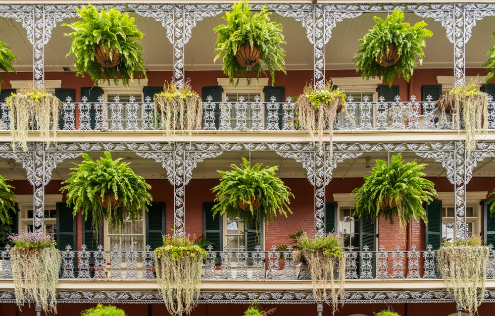Casa com sacadas de ferro forjado e vasos de flores pendurados na Royal Street, no French Quarter
