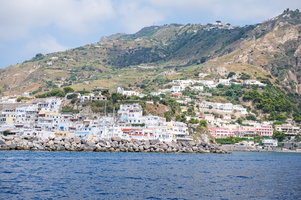 Casas coloridas e o quebra-mar de pedra em Sant'Angelo, na ilha de Ischia