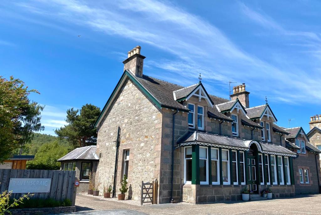 Fachada de pedra da Ravenscraig Guest House sob um céu azul em Aviemore