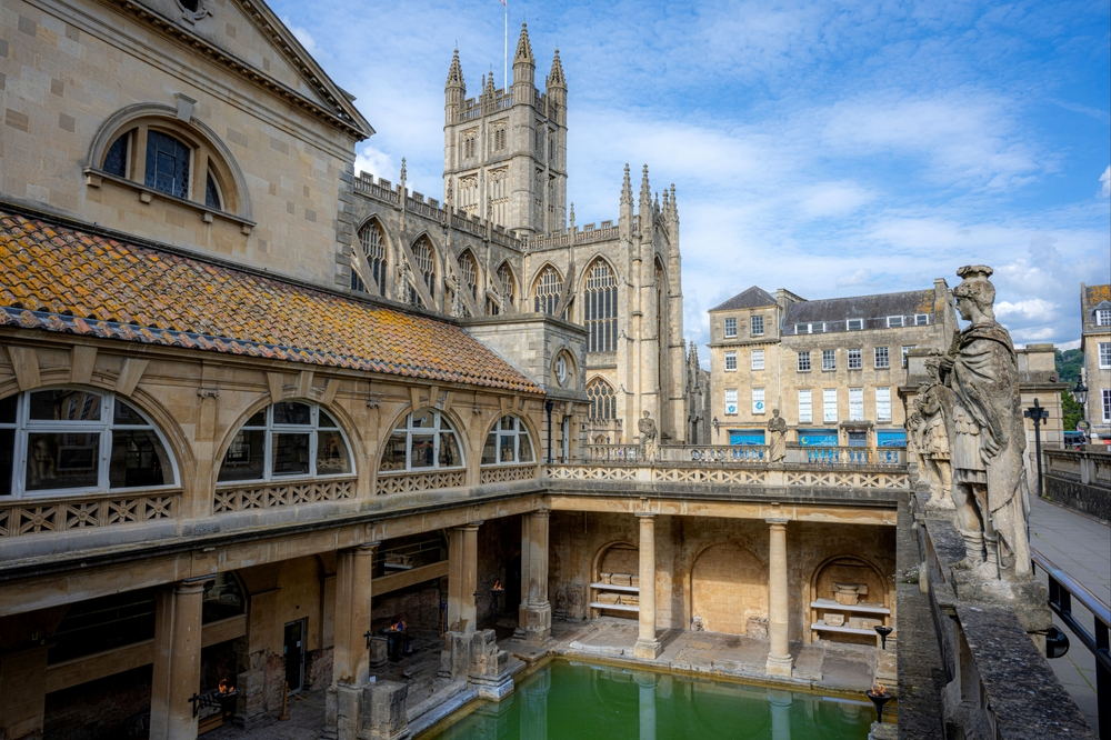 As históricas Termas Romanas no centro de Bath, com a Abadia de Bath ao fundo