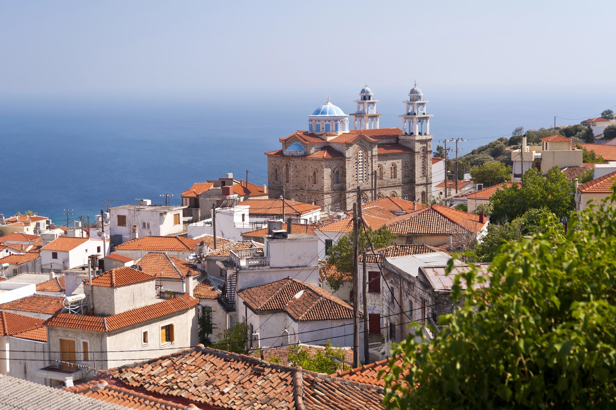 Igreja e telhados em Marathokampos com o mar ao fundo
