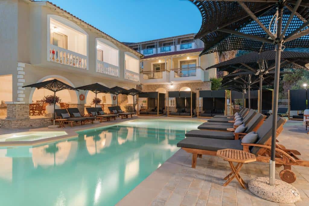 Piscina iluminada e espreguiçadeiras no Ino Hotel & Suites
