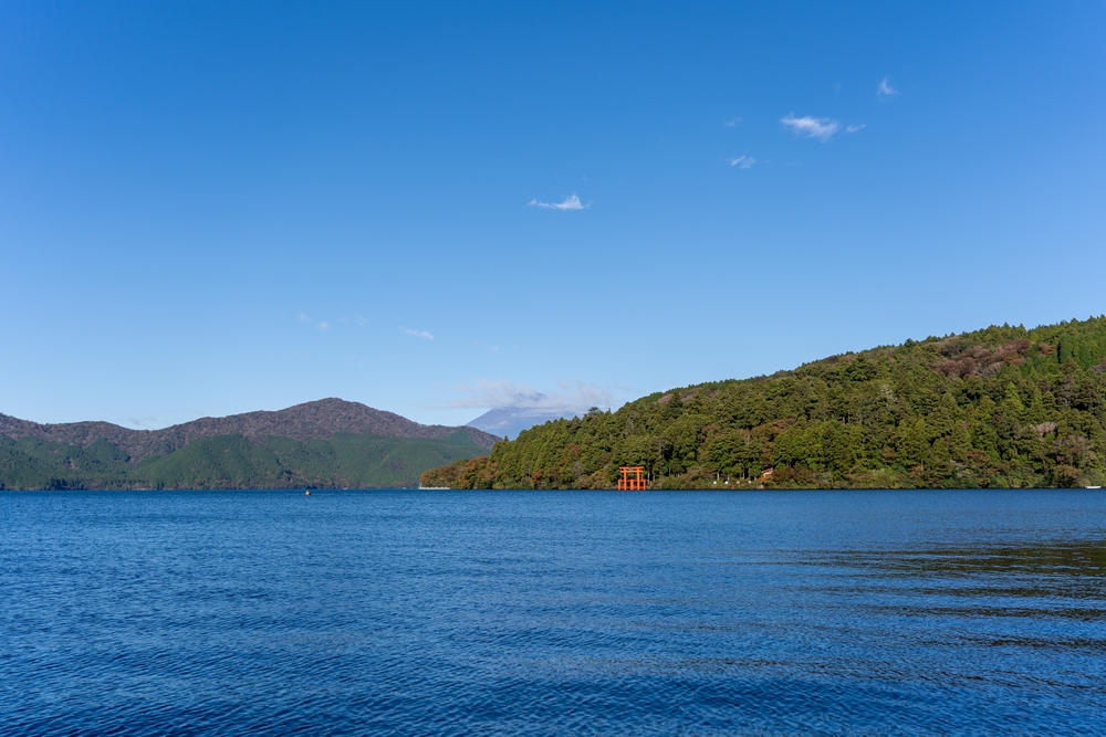 O portal torii vermelho no Lago Ashi, em Hakone, com o Monte Fuji ao fundo