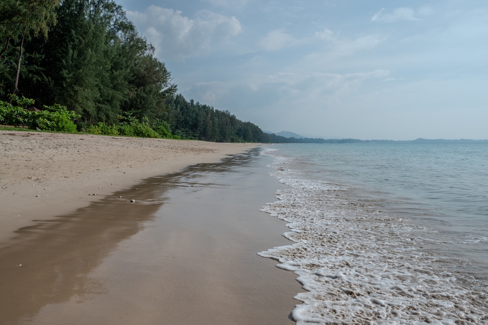 Praia de Bang Sak, ao norte de Khao Lak, com areia dourada e água cristalina