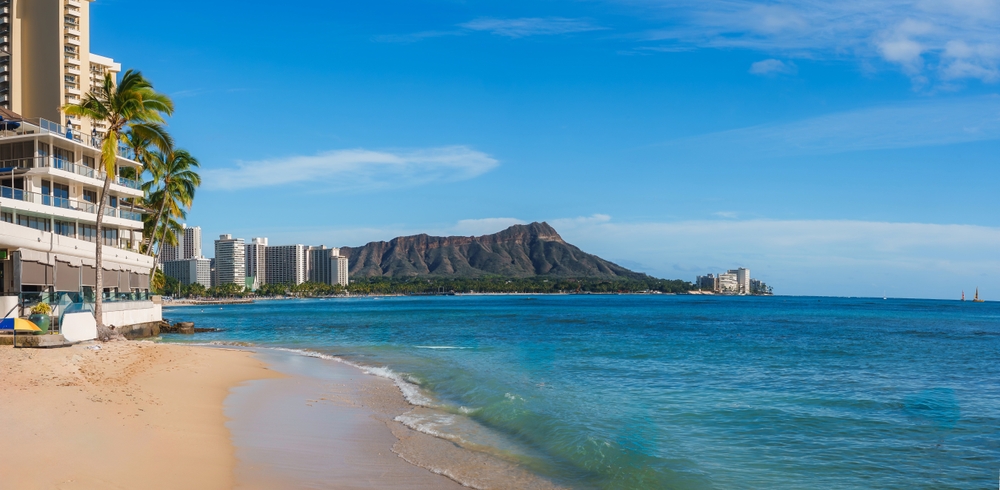 Praia de Waikiki com palmeiras, hotéis e Diamond Head ao fundo