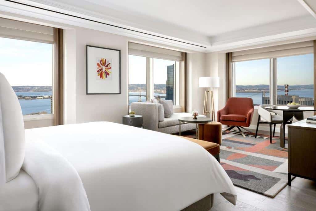 Quarto e sala de estar com janelas grandes no Four Seasons Hotel San Francisco at Embarcadero