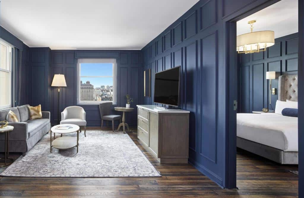 Sala de estar e quarto com paredes azul-escuras no Beacon Grand