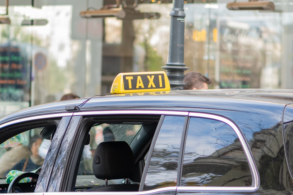 Táxi com placa amarela em uma rua de Viena