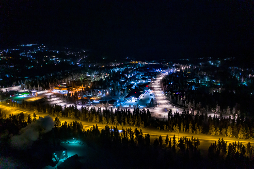 Vista aérea de Saariselkä à noite com luzes coloridas na Lapônia