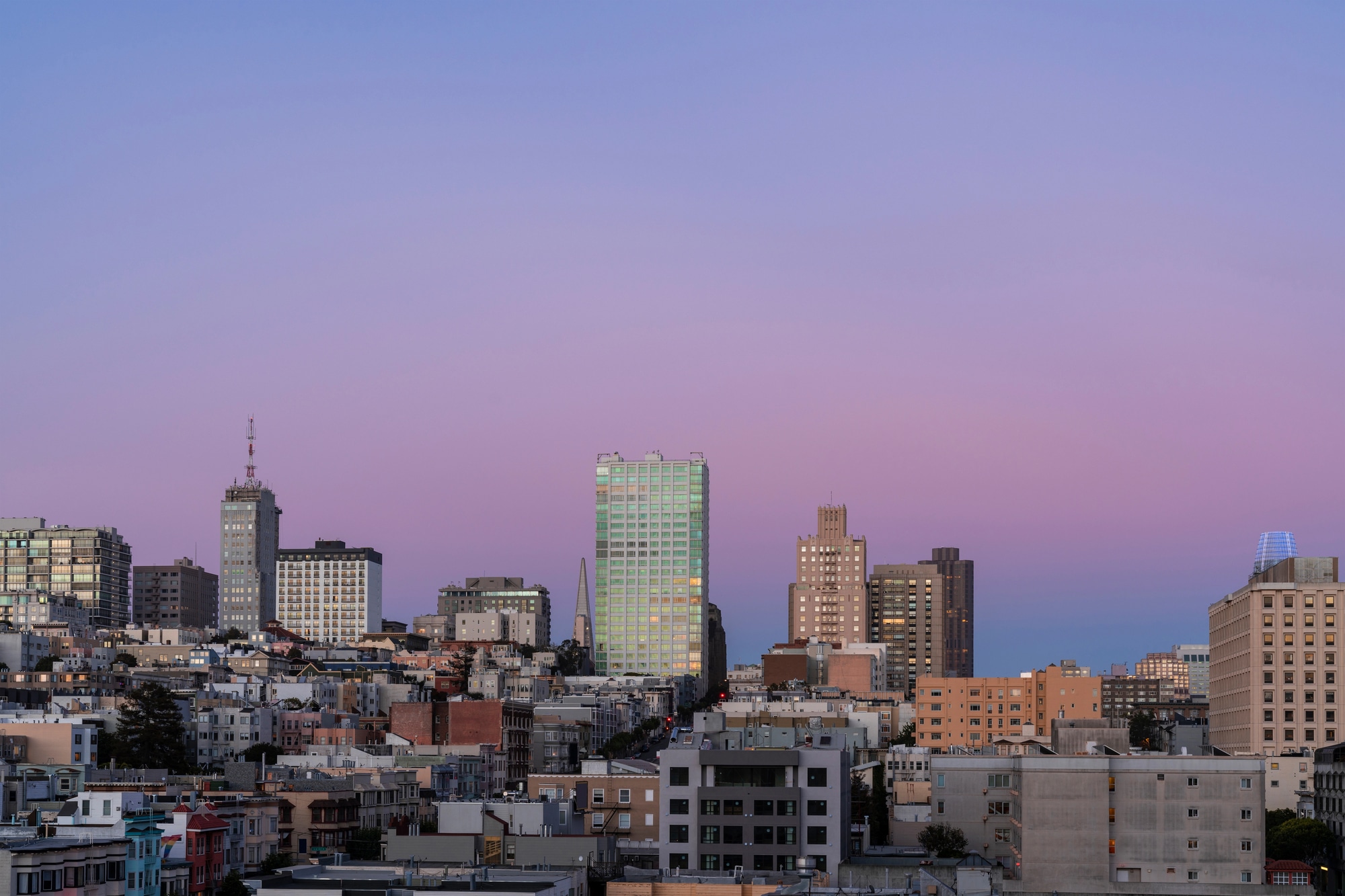 Vista dos prédios e colinas de São Francisco sob um céu rosado de fim de tarde
